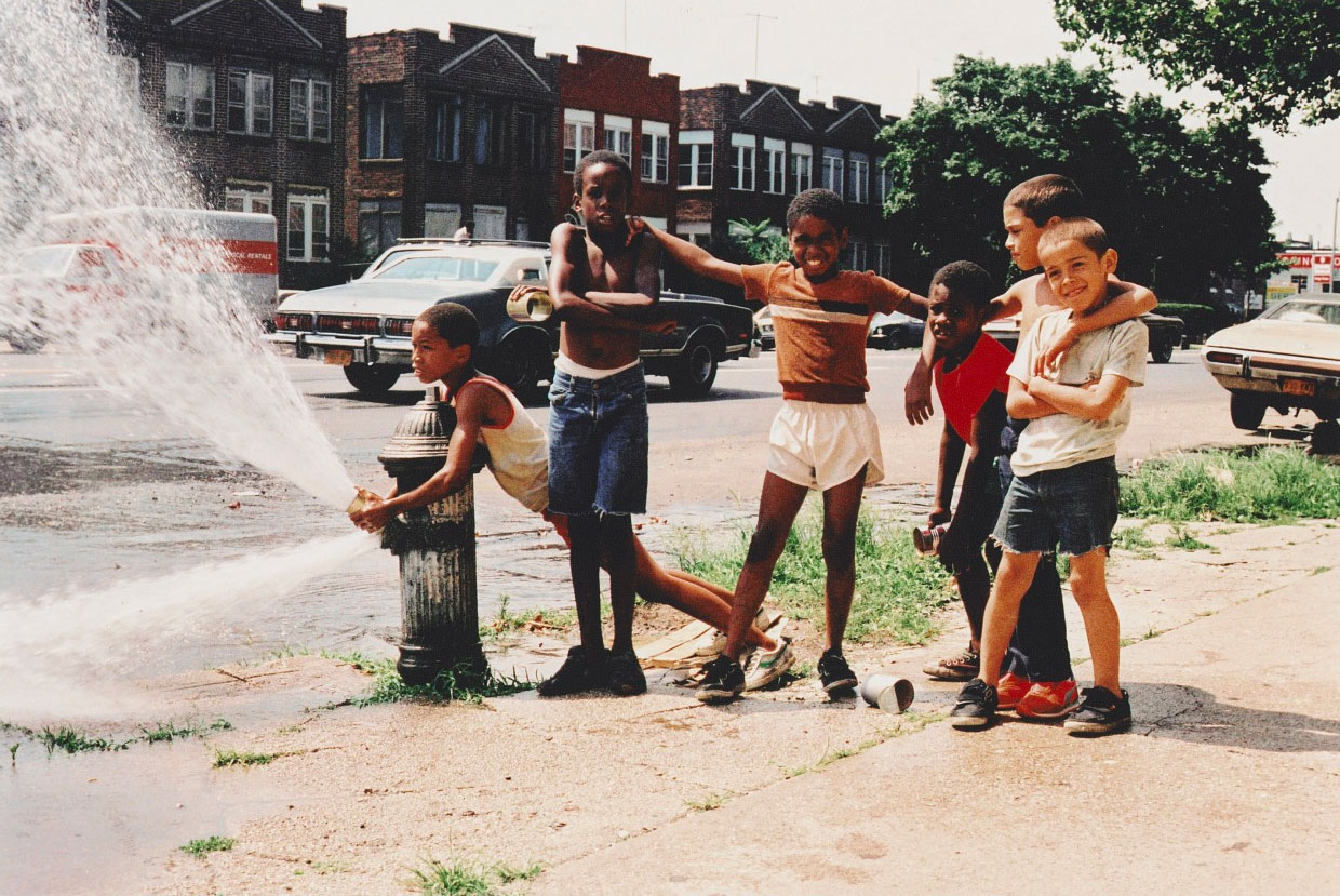 A group of friends playing by a fire hydrant.