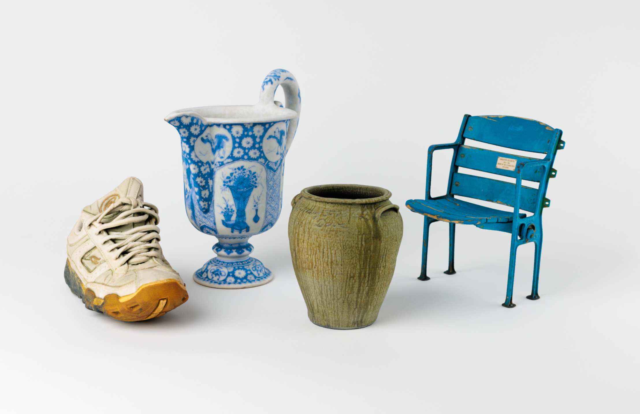 Four 3D printed objects - a shoe, pitcher, vase, and small stadium seat.
