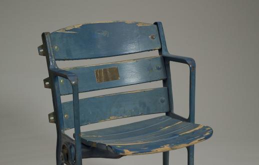 The seat is wood and metal painted blue, with remnants of green underneath. 