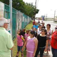 Image of people viewing a photo on a fence  